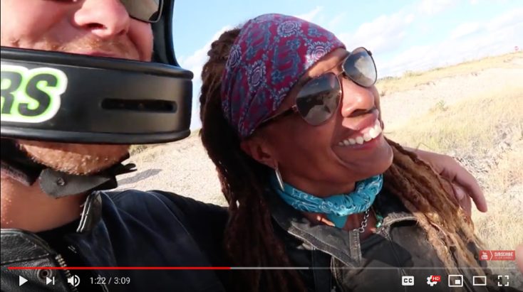 Still of Gevin smiling in a bandana and sunglasses
