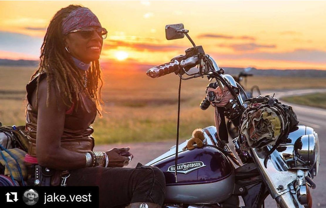 Gevin at sunset beside her motorcycle